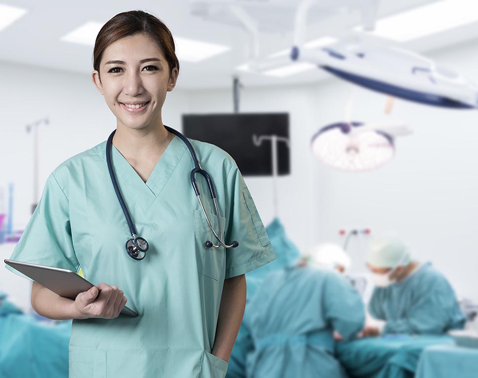 Female ER nurse in surgery scrubs smiling.